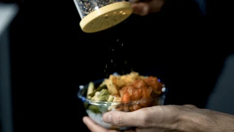 Young man making a prawn poke bowl with rice, avocado, pineapple and veggies Stock Footage 128927627