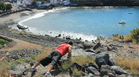 Young man making push-ups on the beach Stock Footage 35507870