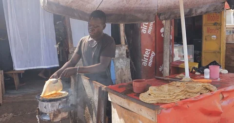Young man is making a rolex, a popular street food in Uganda, combining an egg Stock Footage 109490580