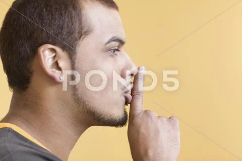Young man making 'shh' sound Stock Photos