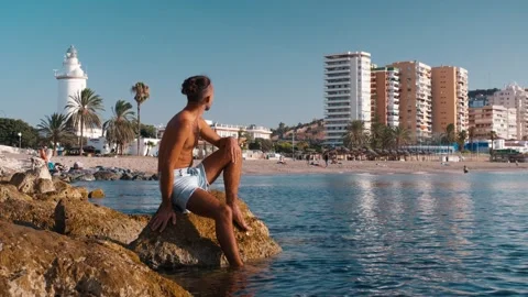 Young man with man bun gazing at distant city skyline, embodying digital no.. Stock Footage 344059257