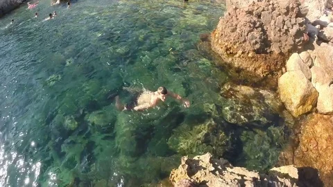 A young man man floating on the surface of the water, floating starfish floating Stock Footage 80166594