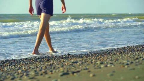 A young man, a man walking on the waves on the seashore. Stock Footage 162191183