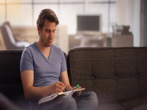 Young man marking text in a book Stock Footage 78607256