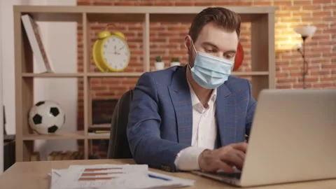 A young man in a mask in the office greets someone with a gesture 動画素材 190538434