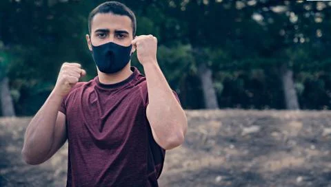 Young man with mask practicing boxing in guard position. Stock Photos