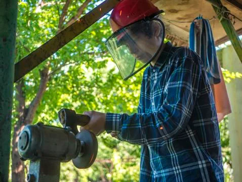 Young man in mask working at the grinder Stock Photos