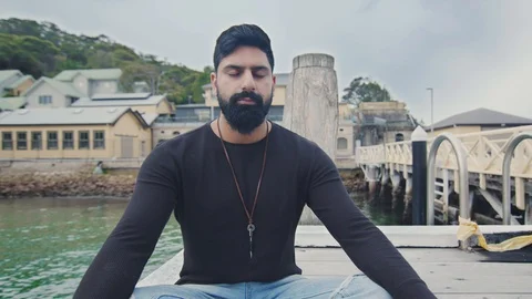 Young Man Meditates Alone Sitting on Wharf. Circle Shot Right. Mid Shot Stock Footage 129245938