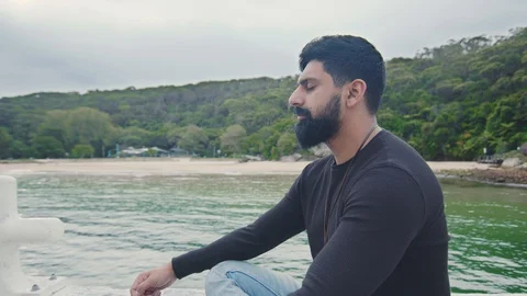 Young Man Meditates Alone Sitting on Wharf. Circle Shot Left. Mid Shot Stock Footage 129246332