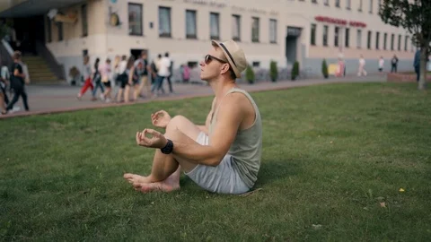 Young man meditating in the middle of the street Stock Footage