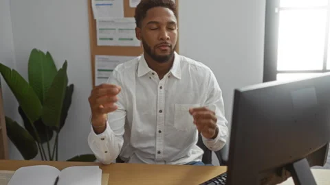 Young man meditating while working at computer in indoor office setting sho.. Stock Footage 300309016