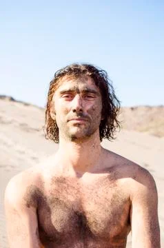 Young man with medium-length wavy hair is not wearing a T-shirt and is covere Fotos de archivo
