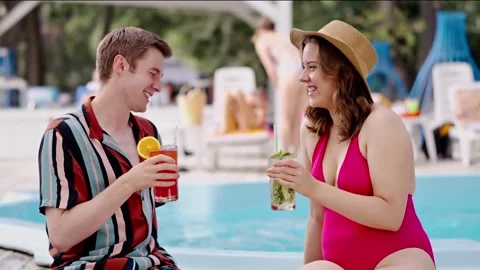 Young man meet hot chic girl in red bikini drinks alcohol at poolside. Couple Stock Footage 256802845