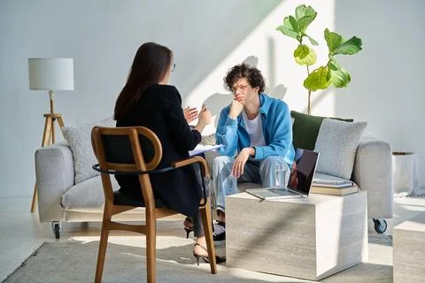 Young man in mental session talking with professional psychologist Stock Photos
