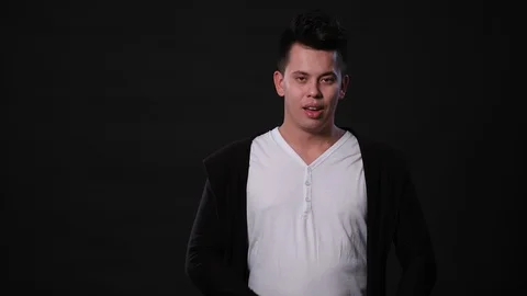 A Young Man Mimicing Against a Black Background Stock Footage 87258482
