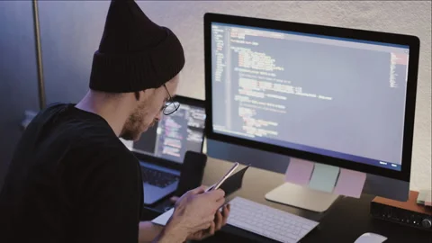 Young man mobile developer studying on a computer, taking notes. Stock Footage 145088125