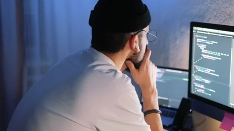 Young man mobile developer writes program code on a computer Stock Footage 166691108