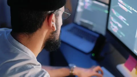 Young man mobile developer writes program code on a computer Stock Footage 166691341