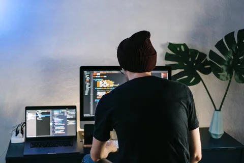 Young man mobile developer writes program code on a computer. 스톡 사진