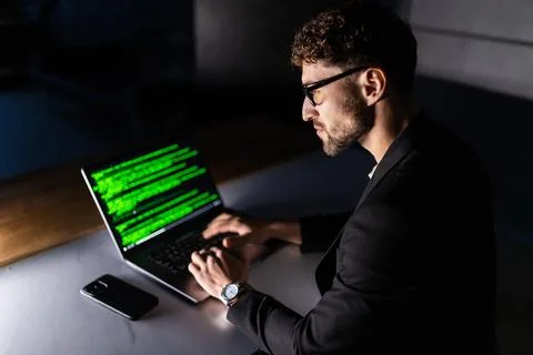Young man mobile developer writes program code on a computer, programmer work Foto stock