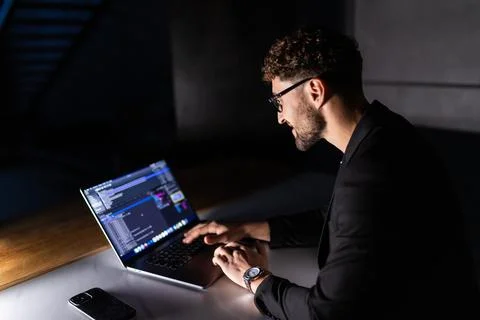 Young man mobile developer writes program code on a computer, programmer work Stockfoto's