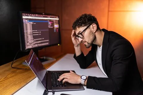 Young man mobile developer writes program code on a computer, programmer work Foto stock