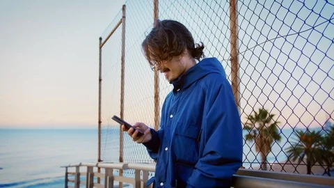 Young man with mobile phone app connected to internet checking social network Stock Footage 100861468