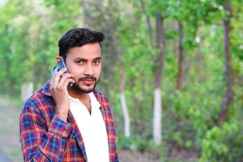 Young man model talking with his cell phone in a forest Stock Photos