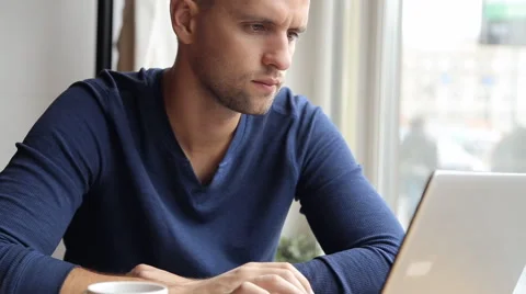 Young man with modern laptop in cafe Stock Footage