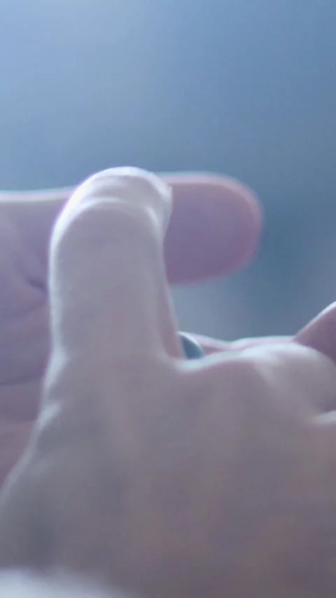 Young man moisturizing hands, applying lotion to his skin, skincare vertical 4K Video stock 345737443