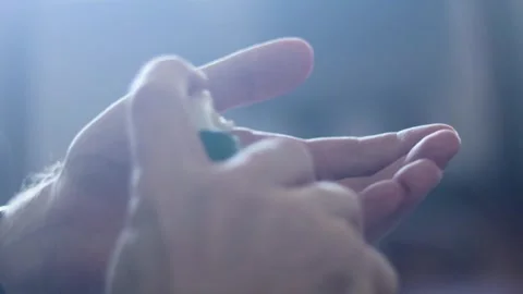 Young man moisturizing hands, applying lotion to his skin, skincare routine, 4K Stock Footage 345737474