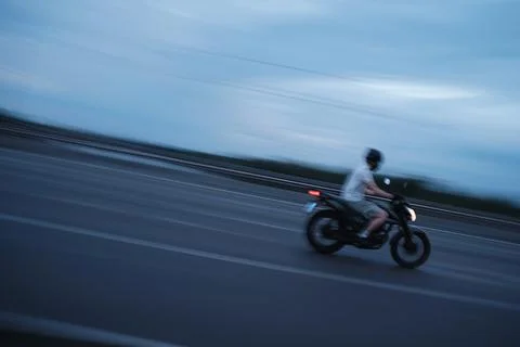 Young man on a motorcycle without protective clothing. Stock Photos