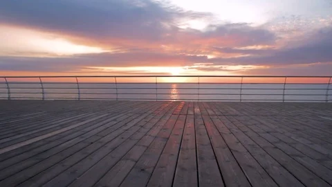 Young man with mountain bike on seafront during sunset or sunrise 動画素材 75772385