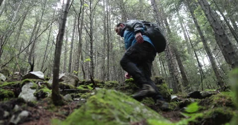 A young man in a mountain hiking with a backpack Stock Footage 243723068