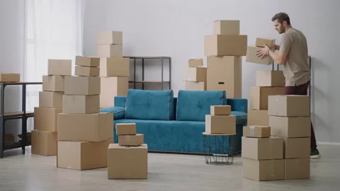 Young Man moves in Cardboard Boxes. Young male Moves In to New Apartment. A man Stock Footage 149323608