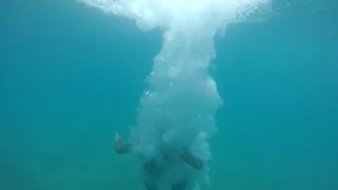 Young man moves down in transparent sea waters with many blebs in slow motion Video stock 97693917