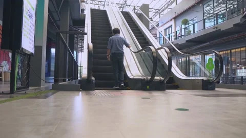 Young man moving on escalator, Modern escalator stairs moving up. Stock Footage 143886811