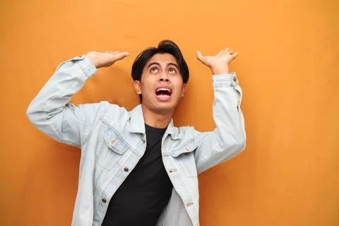 Young man moving head feeling heavy isolated on yellow background Stock Photos