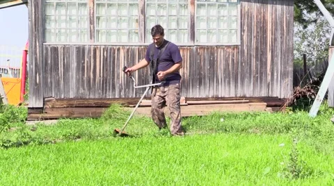 Young man mows the grass Stock Footage 41304012