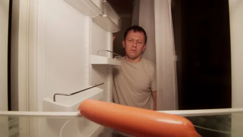 Young man at night at home opens the refrigerator and closes the dissatisfied Stock Footage 144208571