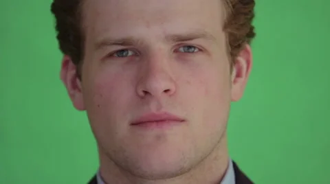 Young man nodding to camera in front of greenscreen Stock Footage 40960015