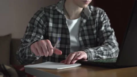 A young man notes an online lecture in a notebook. distance education. slide Stock Footage 237987239