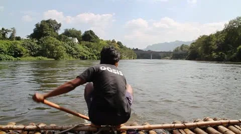 The young man with an oar operates a raft on the river in jungle Vídeo Stock 8948908