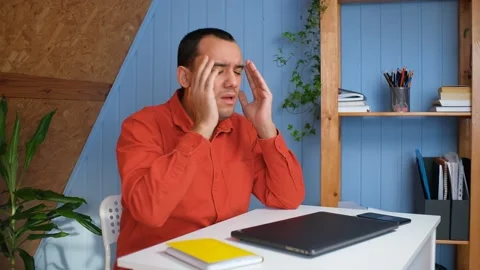 Young man in office is overworked and tired. Has headache of pressure and stress Stock Footage 148228352