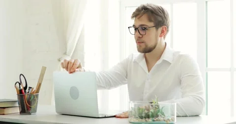 Young man office worker working typing on laptop at table in modern office. Stock Footage 132101007