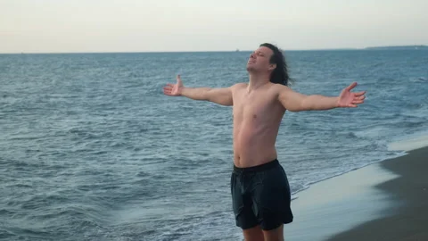 Young man opening arms at beach enjoying freedom sea breeze wind. Stock-Footage 311474553