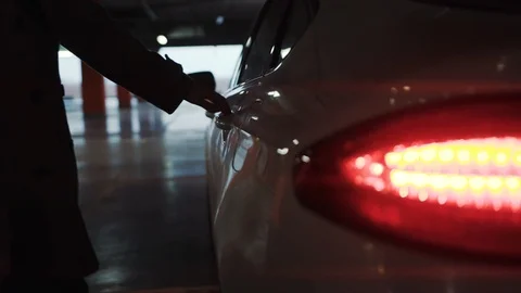 Young man opening car door and sitting on parking male adult guy human lights Stock Footage 112156790