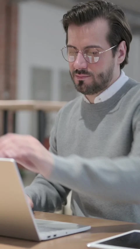 Young Man Opening Laptop while Sitting in Office, Vertical Video Stock Footage 339580818