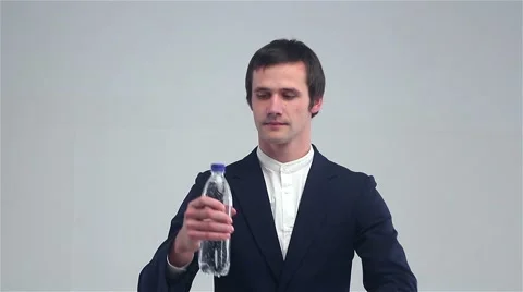 Young man opens a bottle and drink water Stock Footage 68997245
