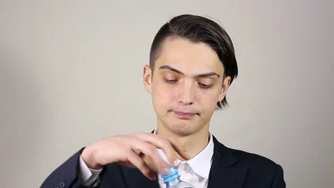 Young man opens a bottle and drink water Stockbeeldmateriaal 73650654